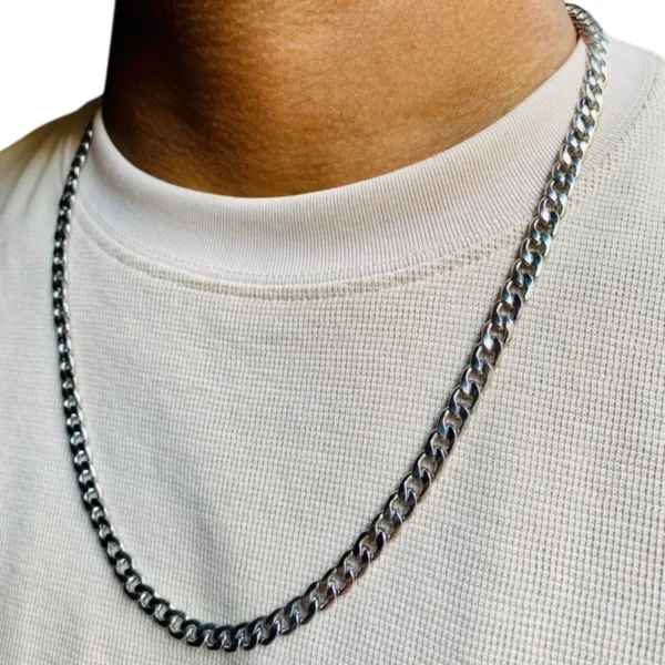 Primer plano de la cadena de acero inoxidable grumet plateada en el cuello de un hombre.