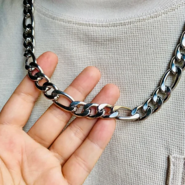 Cadena de acero inoxidable plateada estilo Cartier de 60 cm y 11 mm en la mano de un hombre.