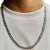 Cadena de acero inoxidable plateada estilo grumet 60cm-5mm en el cuello de un hombre con camiseta blanca.