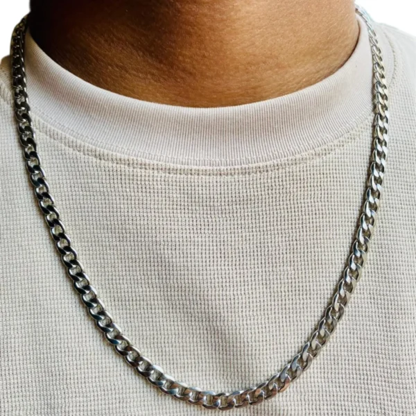 Cadena de acero inoxidable plateada estilo grumet 60cm-5mm en el cuello de un hombre con camiseta blanca.
